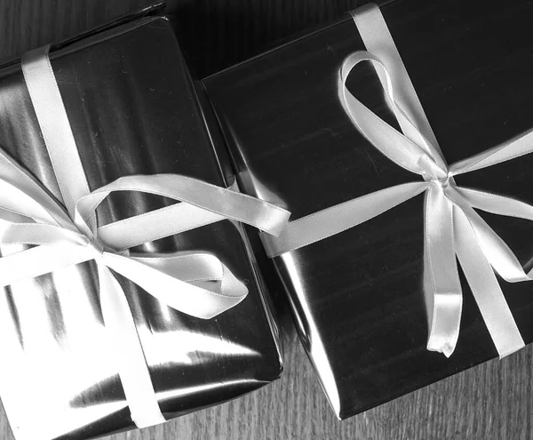 Dva dárky svázané stuhou v černé a bílé. — Stock fotografie