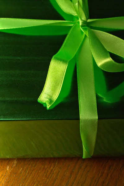 Yakın çekim kurdelesiyle bağlanmış yeşil bir hediye kutusu. Dikey enstantane — Stok fotoğraf