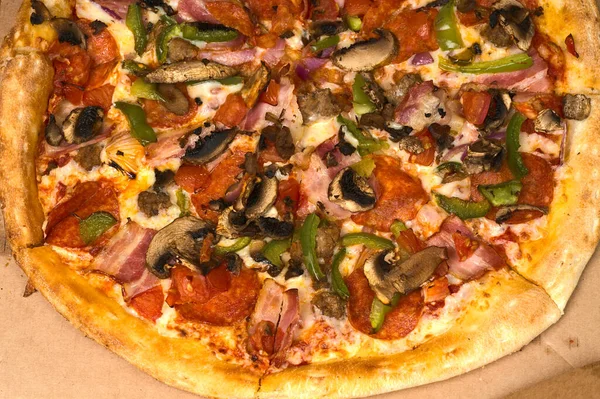 Half of the closeup pizza with mushrooms with bacon and green pepper. — Stock Photo, Image