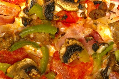 Mantarlı, domatesli ve biberli yakın çekim pizza.