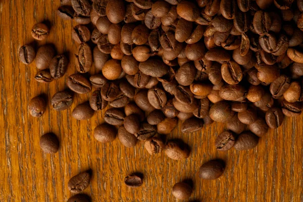 Chicchi di caffè tostati su uno sfondo di legno da vicino vista dall'alto — Foto Stock