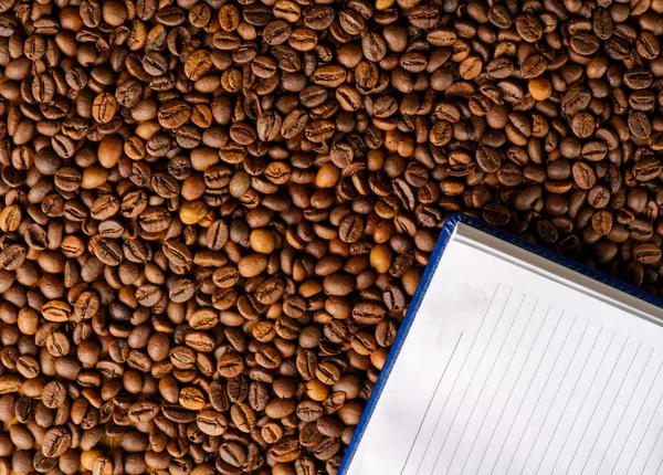 Il concetto di lavoro intellettuale di successo. C'è un diario per le note sui chicchi di caffè tostati. — Foto Stock