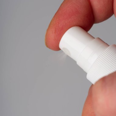 Elinde 70 alkol olan antiseptik sprey. Beyaz bir arkaplanda.