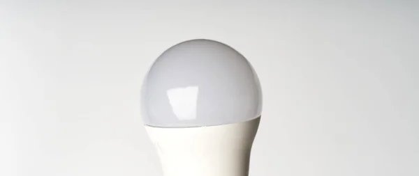 A parte superior de uma lâmpada economizadora de energia em um fundo branco. — Fotografia de Stock
