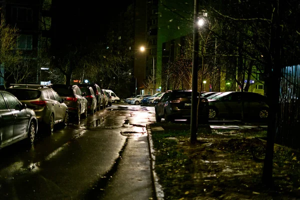 Moscow, Russia - october 27 2021: A street of a night metropolis with cars standing in a row and snow falling — 스톡 사진