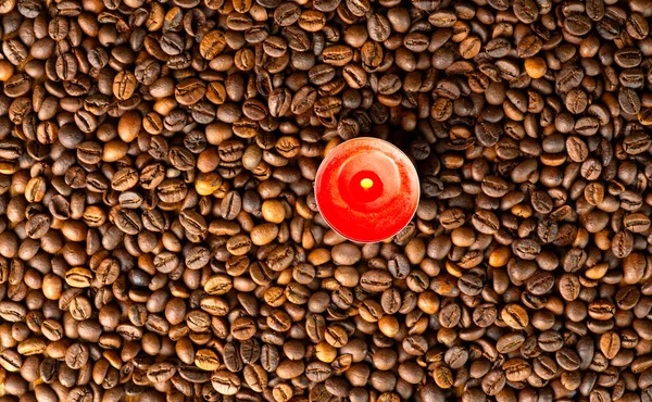 Кофе и новогодние праздники. Текстура кофейных бобов и красная небольшая горящая свеча. — стоковое фото