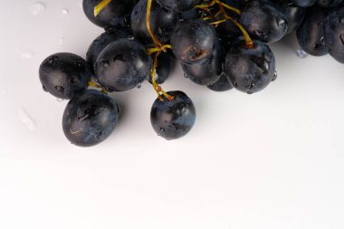 Beyaz arka planda siyah sulu üzümler.