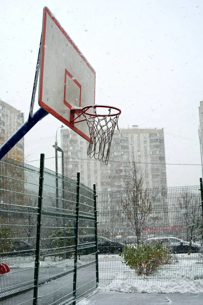 Basketball cerceau avec un bouclier pour le streetball en hiver. Il neige et personne. Instantané vertical — Photo