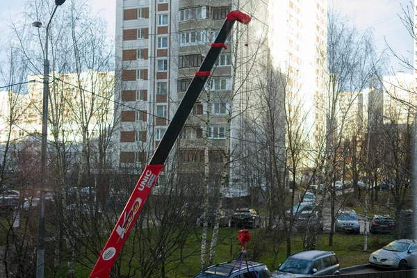 MOSCOW, RUSSIA-22 października 2021: Mały dźwig ładuje coś w mieście przed domem. Widoczny jest chowany boom. — Zdjęcie stockowe