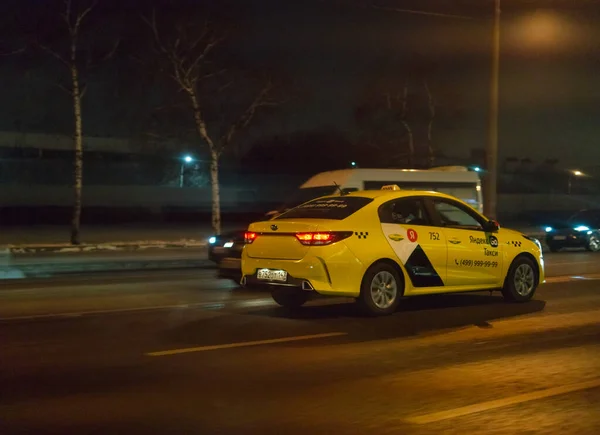 MOSCÚ, RUSIA-11 de diciembre de 2021: Un taxi conduciendo por las calles nocturnas de la ciudad. Oscuro — Foto de Stock