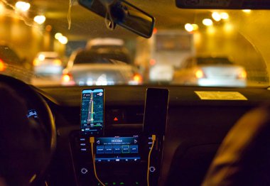 MOSCOW, RUSSIA-11 Aralık 2021: araba gece geç saatlerde içeride. Sürücü ve yönlendirme programı olan bir cep telefonu görülebilir. Radyo açık ve Moskova yazıtları var.