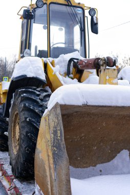 MOSCOW, Rusya- 11 Aralık 2021: kazıcı karla kaplı bir çekicinin üzerinde duran bir kova ile ayakta duruyor. Kapat