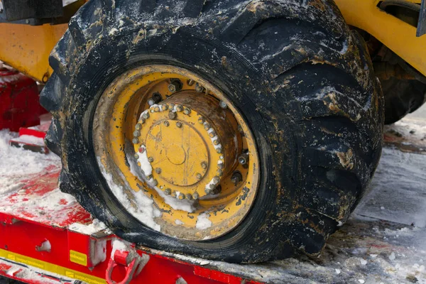MOSCÚ, RUSIA - 11 de diciembre de 2021: Una gran rueda desinflada de una excavadora de pie sobre una grúa. Equipos de construcción rotos —  Fotos de Stock