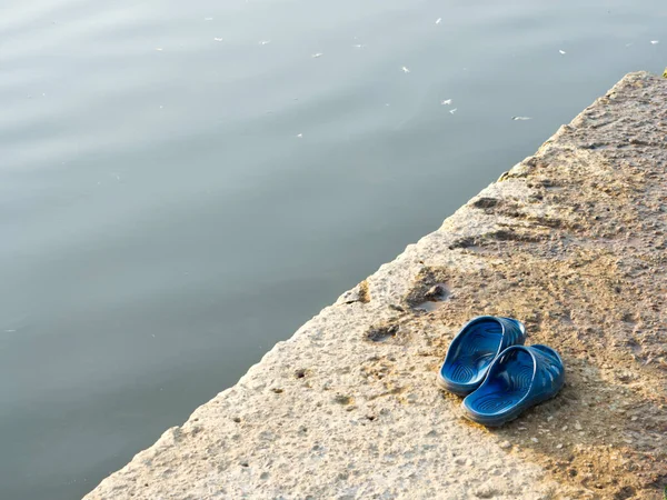 Dinlenme kavramı. Parmak arası terlikler köprüde, suyun yanında.