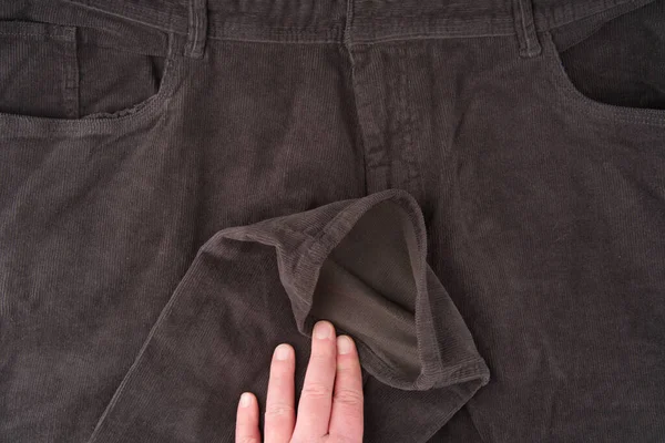 La parte anteriore e la mosca dei pantaloni scuri in velluto a coste e il braccio con la gamba. Chiudere — Foto Stock