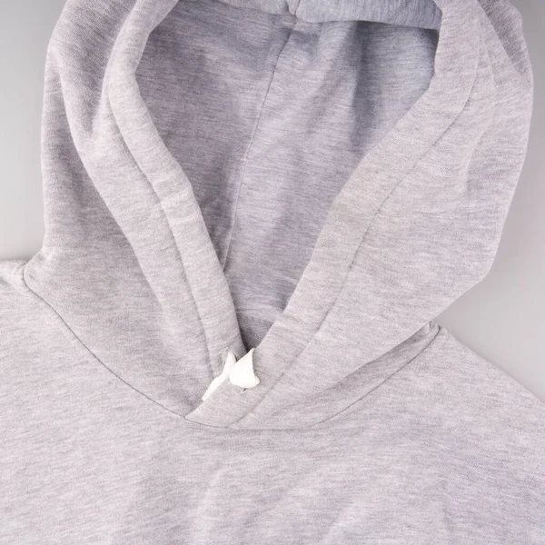 Sweatshirt with a hood of light color on a gray background closeup — Stock Photo, Image