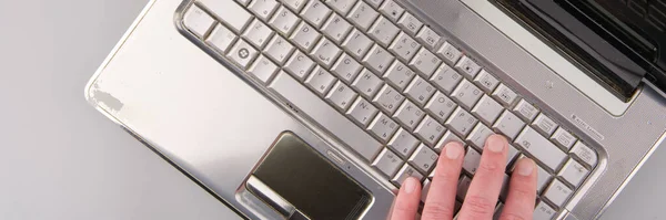MOSCÚ, RUSIA-23 de febrero de 2022: Un viejo portátil HP. El teclado y parte de la mano en él son visibles. Vista superior —  Fotos de Stock