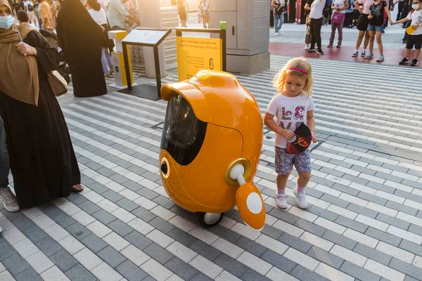 阿联酋迪拜 2021年10月15日在2020世博会上拍摄了一个小女孩与可爱的小机器人玩耍的镜头 免版税图库图片
