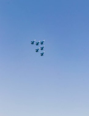 Askeri uçaklar açık mavi gökyüzünde gösteri yapıyor.