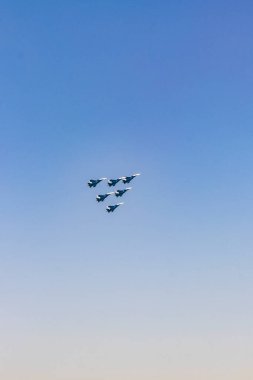 Askeri uçaklar açık mavi gökyüzünde gösteri yapıyor.