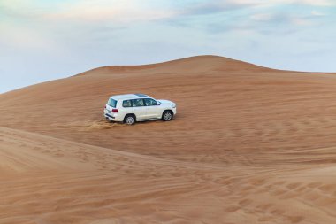 Dubai, BAE - 12.15.2021 Kum tepeciğinde bir SUV görüntüsü.