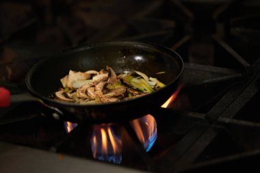 Kızarmış pizza mantarları kızgın sobanın tepesinde pişiyor.