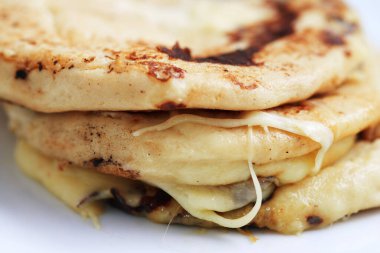 El Salvador 'dan Pupusas' ı kapayın. Beyaz bir tabakta el yazısıyla izole edilmiş.