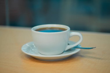 Kahve fincanı, bir barda ahşap tezgahın camına yakın çekim.