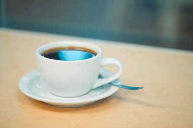 Kahve fincanı, bir barda ahşap tezgahın camına yakın çekim.