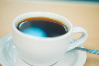 Kahve fincanı, bir barda ahşap tezgahın camına yakın çekim.