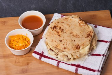 Ahşap bir tahtanın üzerinde siyah mermer bir arka planda el yazısı ve sos olan köpek yavruları.