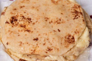 Ahşap bir tahtanın üzerinde siyah mermer bir arka planda el yazısı ve sos olan köpek yavruları.