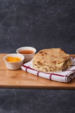 Ahşap bir tahtanın üzerinde siyah mermer bir arka planda el yazısı ve sos olan köpek yavruları.