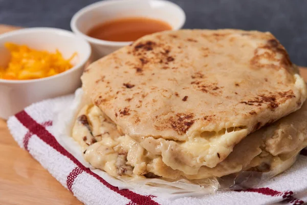 Ahşap bir tahtanın üzerinde siyah mermer bir arka planda el yazısı ve sos olan köpek yavruları.