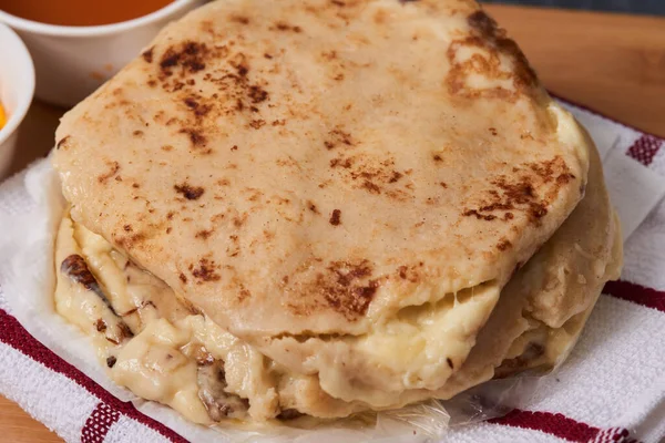 Ahşap bir tahtanın üzerinde siyah mermer bir arka planda el yazısı ve sos olan köpek yavruları.