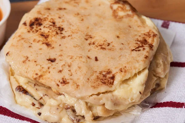 Ahşap bir tahtanın üzerinde siyah mermer bir arka planda el yazısı ve sos olan köpek yavruları.