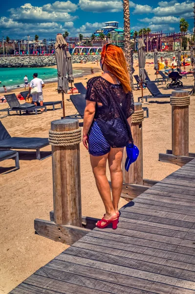 Güneşli bir günde Dubai, BAE 'de sahil iskelesinde bir kadın dikiliyor..