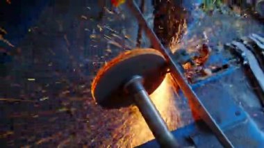 Close-up view of blacksmith sharpening a sword.