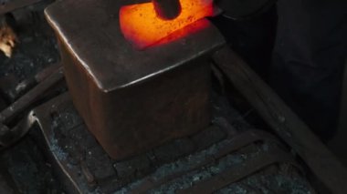 Demircinin yakın çekim görüntüsü kızgın metali dövüyor.