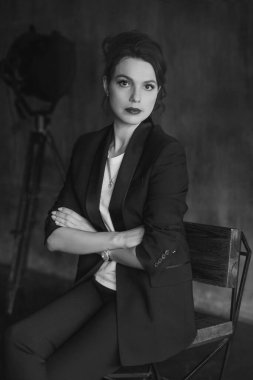 Takım elbiseli şık genç kızlar fotoğraf stüdyosunda poz verirler..