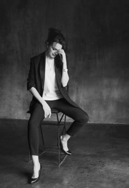 Takım elbiseli şık genç kızlar fotoğraf stüdyosunda poz verirler..