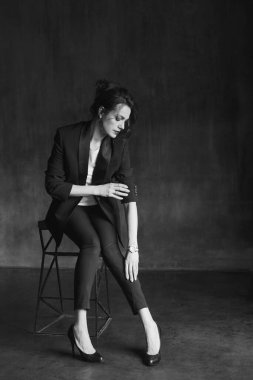 Takım elbiseli şık genç kızlar fotoğraf stüdyosunda poz verirler..