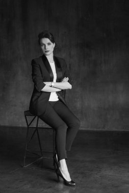 Takım elbiseli şık genç kızlar fotoğraf stüdyosunda poz verirler..