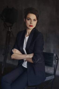 Takım elbiseli şık genç kızlar fotoğraf stüdyosunda poz verirler..