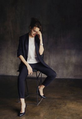 Takım elbiseli şık genç kızlar fotoğraf stüdyosunda poz verirler..