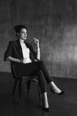 Takım elbiseli şık genç kızlar fotoğraf stüdyosunda poz verirler..