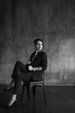 Takım elbiseli şık genç kızlar fotoğraf stüdyosunda poz verirler..