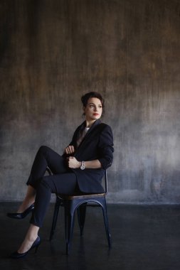 Takım elbiseli şık genç kızlar fotoğraf stüdyosunda poz verirler..