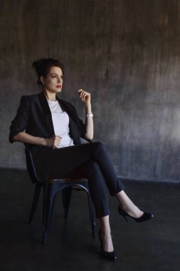 Takım elbiseli şık genç kızlar fotoğraf stüdyosunda poz verirler..