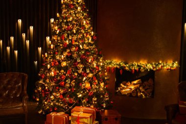 Şenlikli bir iç mekanda şöminenin arka planındaki bir Noel ağacının fotoğrafı. Ağacın altında hediyeler var..